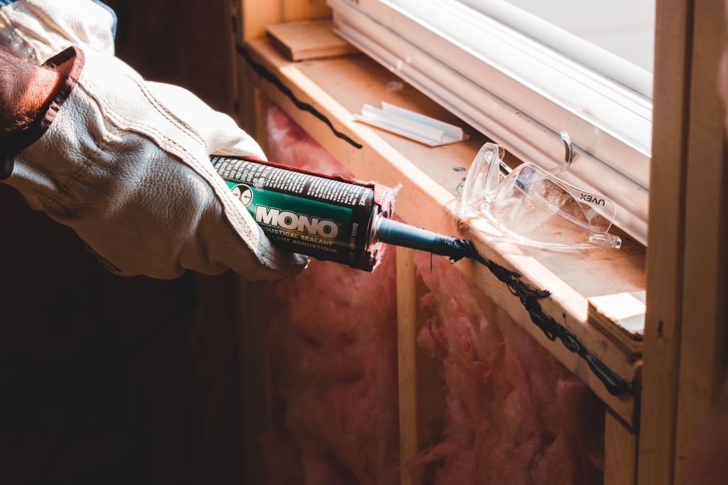 Application de colle et de mastic sur une plinthe