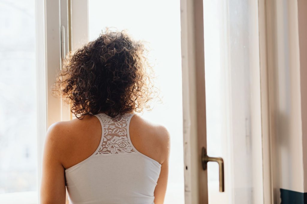 Femme ouvrant une fenêtre pour aérer et chasser l'odeur persistante d'une pièce