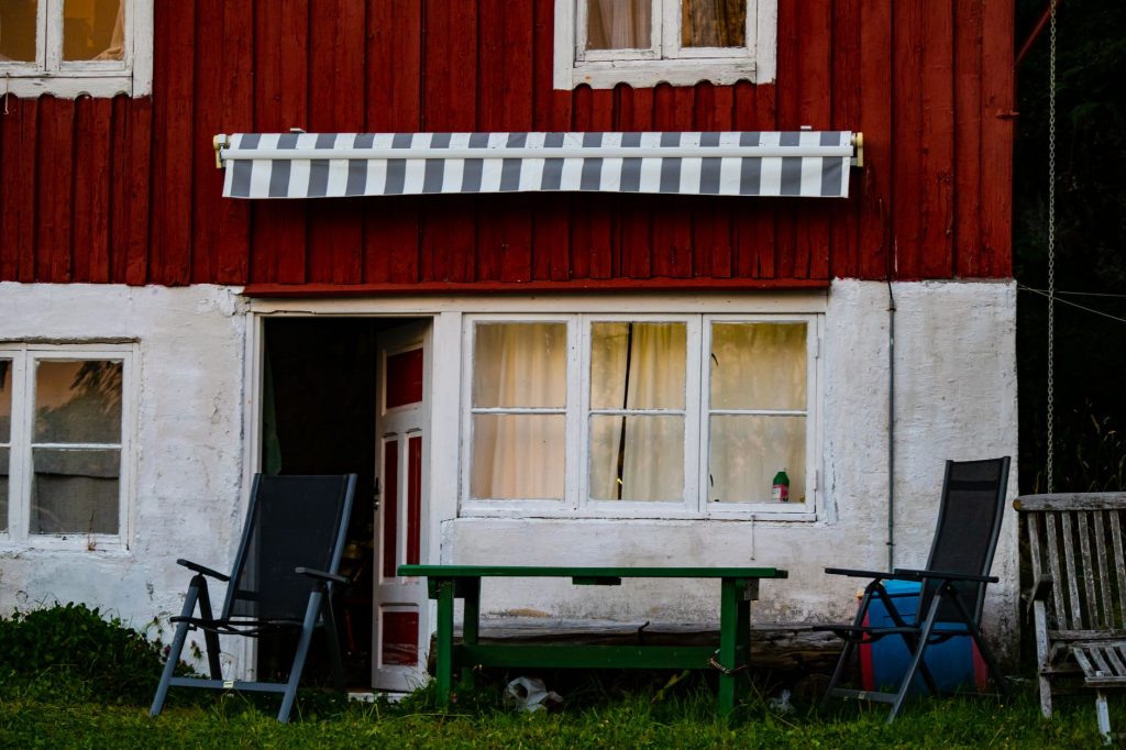 Store banne déployé sur la façade d'une maison au-dessus d'une terrasse