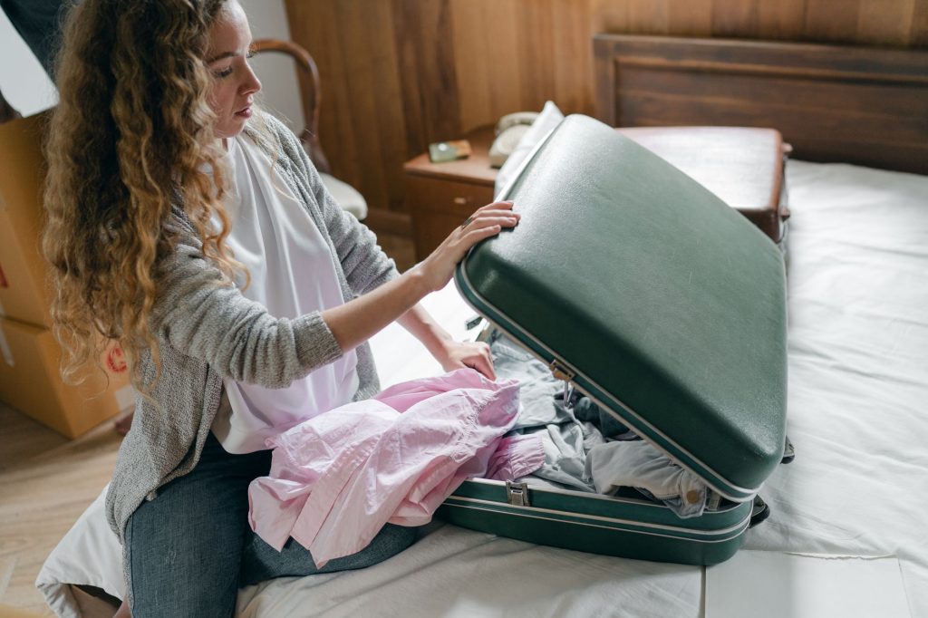 Valise ouverte posée sur un sol dur pour déballer le linge après un voyage