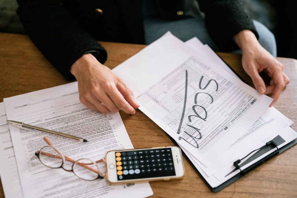 Personne remplissant des documents administratifs à un bureau pour organiser le paiement de ses impôts locaux
