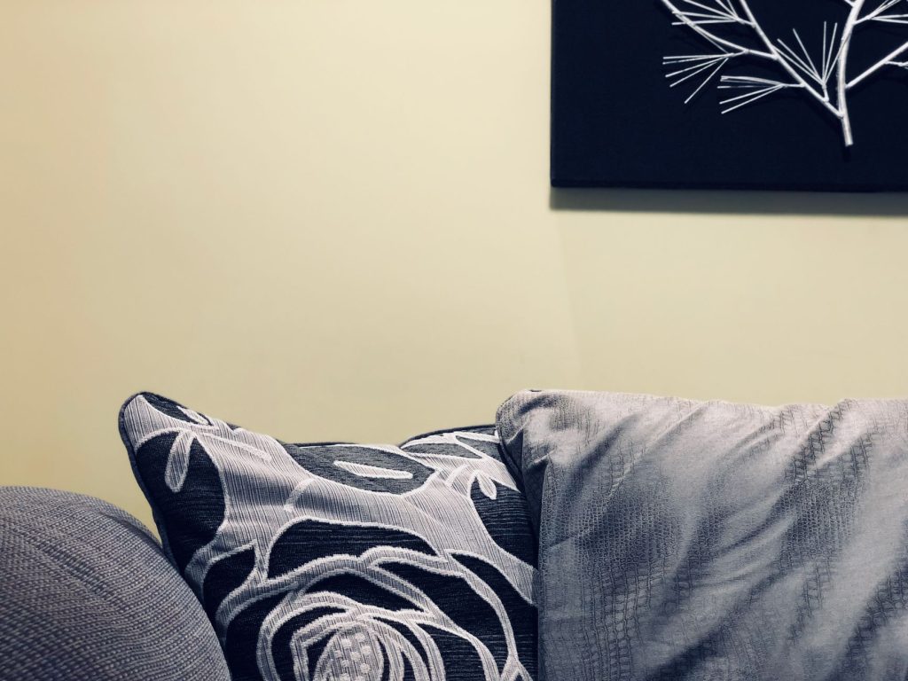 Coussins de tailles et matières différentes disposés en superposition sur un canapé