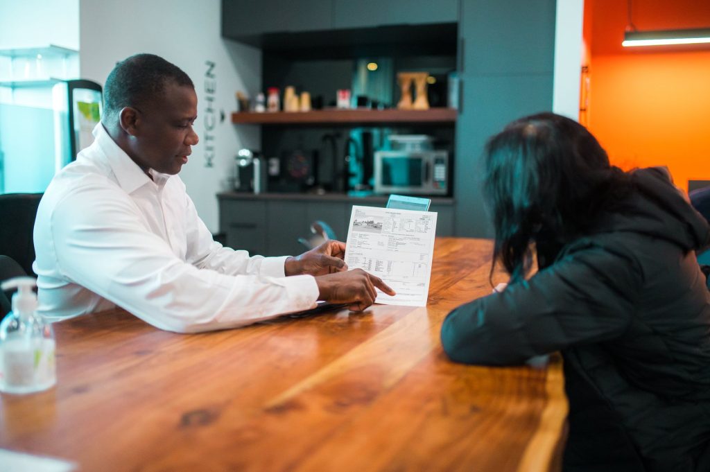 Propriétaire et locataire examinant ensemble un contrat de location autour d'une table