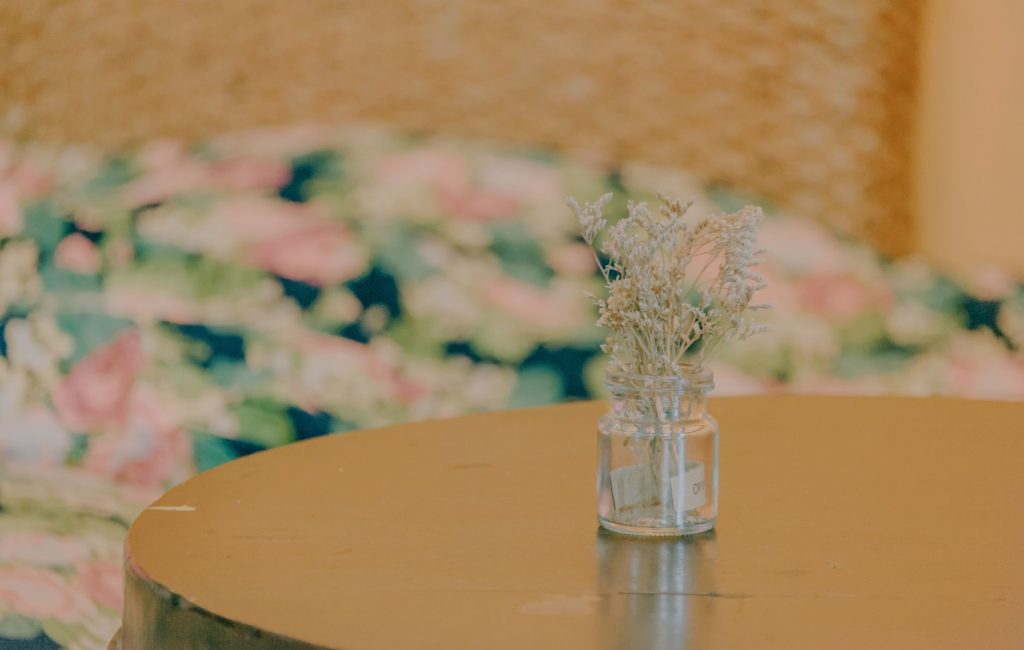 Composition de fleurs séchées dans un vase posé sur une table