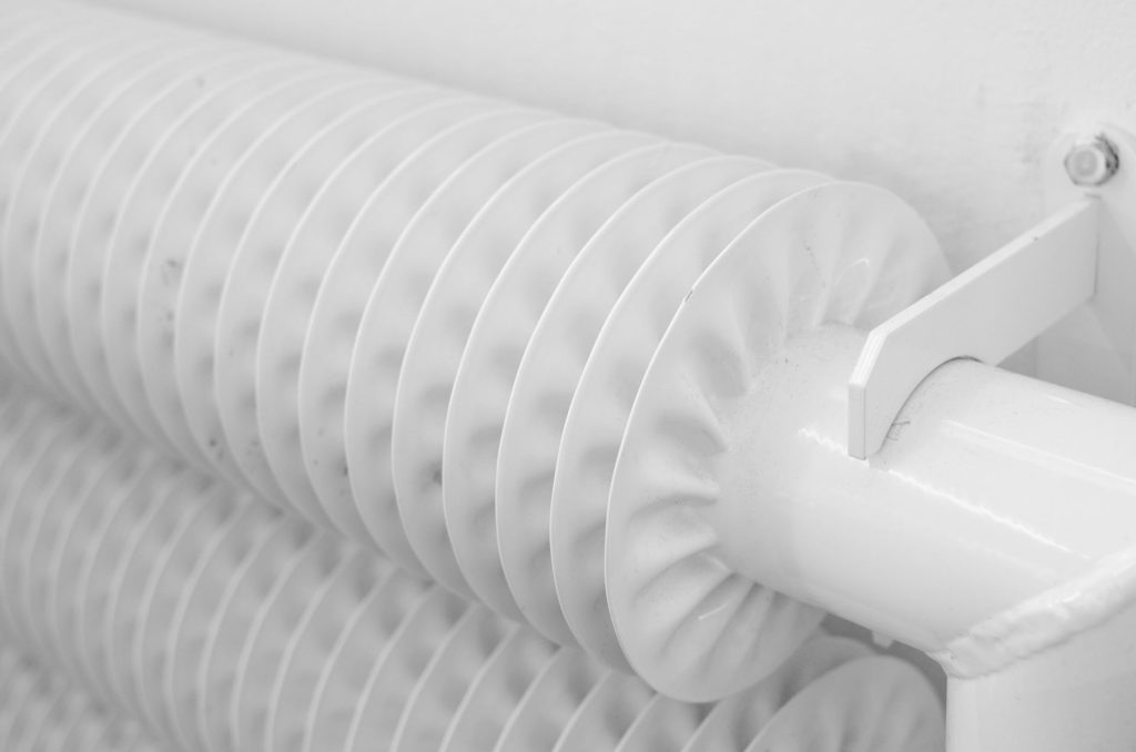 Radiateur mural dans une pièce lumineuse, illustrant le chauffage d'appoint en complément du chauffage central