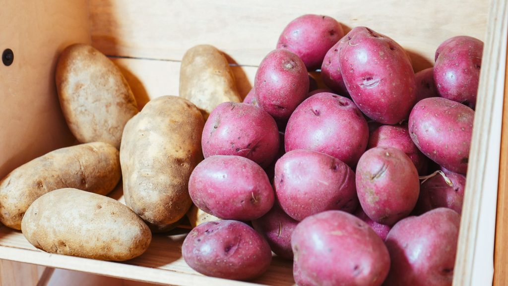 Pommes de terre stockées dans une cagette en bois après récolte