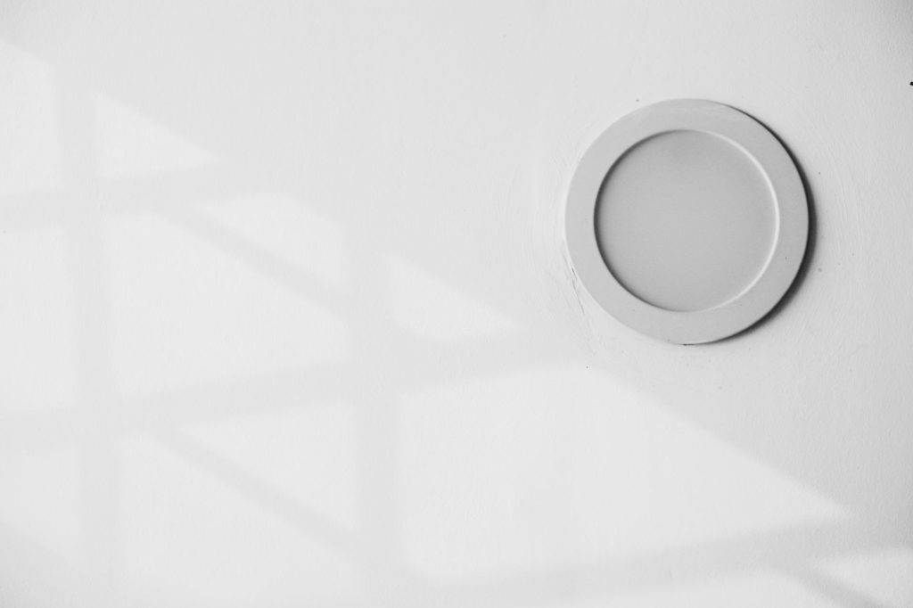 Détecteur rond blanc fixé sur un mur intérieur